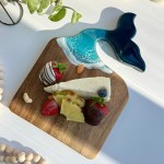 Handcrafted whale tail charcuterie board with ocean wave resin art on natural wood, styled as a coastal-inspired serving tray.