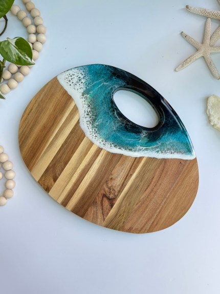 Handmade ocean resin cheese and cutting board by San Jose artist Akkshata Kulkarni, made from wildfire rescued acacia wood.