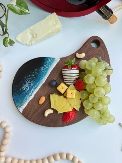 Mango-shaped walnut wood charcuterie board, handcrafted and customizable with engraving, measuring 8 x 12 x 0.6 inches, gift-wrapped for holidays.